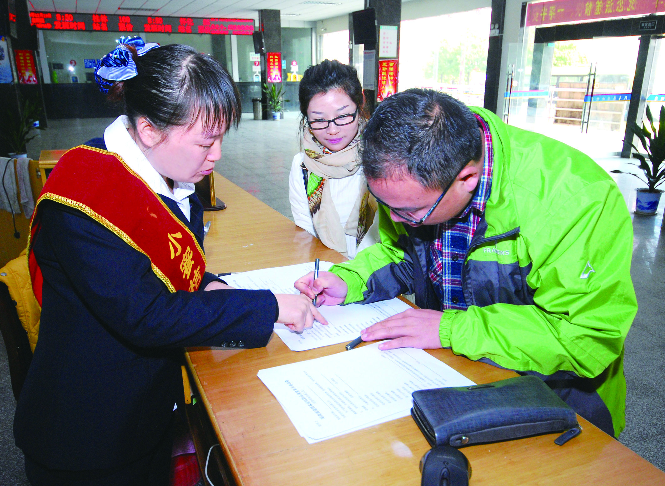 圖為洞口汽車總站站務(wù)人員在熱心為旅客服務(wù)。